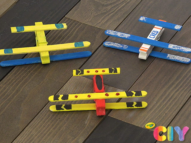 Easy Crafts for kids include this airplane craft which shows three airplanes made from painted popsicle sticks and clothespins.