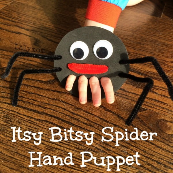 Easy crafts for kids can be puppets like the one shown. A black circle has 4 holes punched in it for a child's fingers to poke through to look like spider legs. the spider has a face.